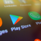 A phone with multiple app icons including messages, Play Store, Phone, Settings and more